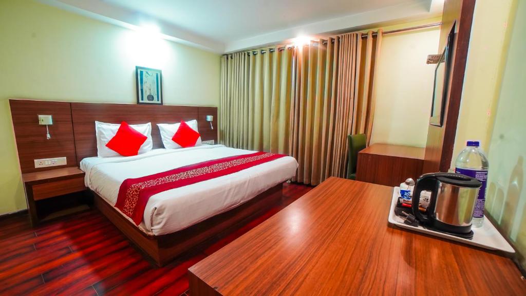 een hotelkamer met een bed met rode kussens bij HOTEL GARNET in Durg