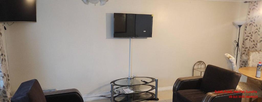 ein Wohnzimmer mit einer Couch und einem Fernseher an der Wand in der Unterkunft Peaceful Family Home in Tilbury with Garden Parking for 3 Cars in Low Street