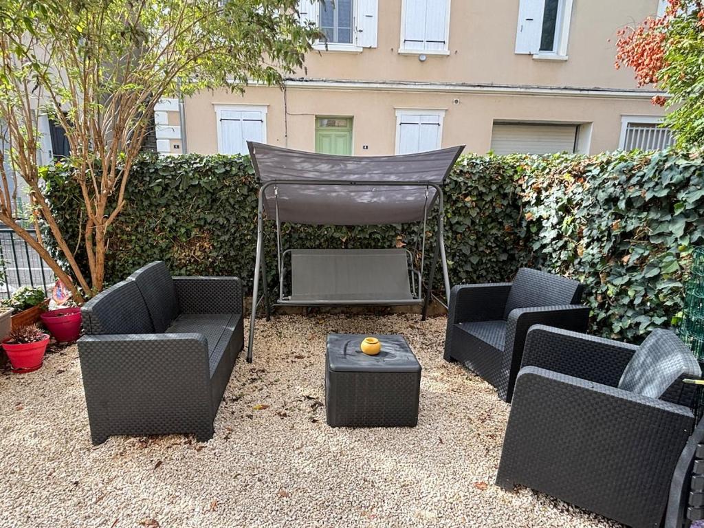 a patio with chairs and a gazebo at Gîte cosy avec jardin in Nyons