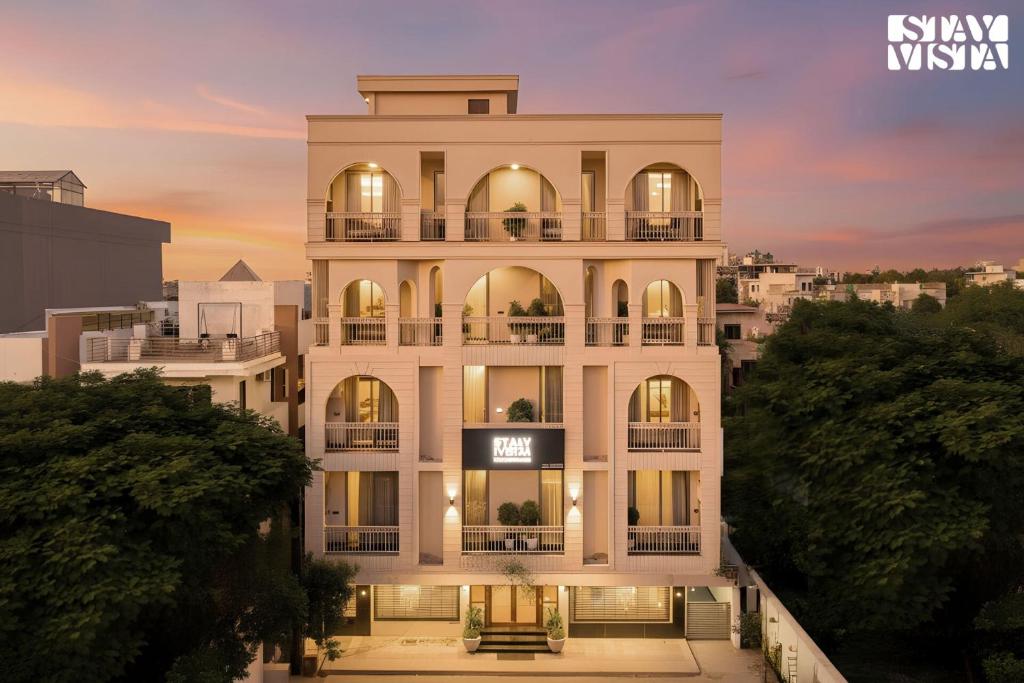 a rendering of a white building with a sunset at StayVista Residences near Cyber City Hub with Gym & Air Purifier in Gurgaon