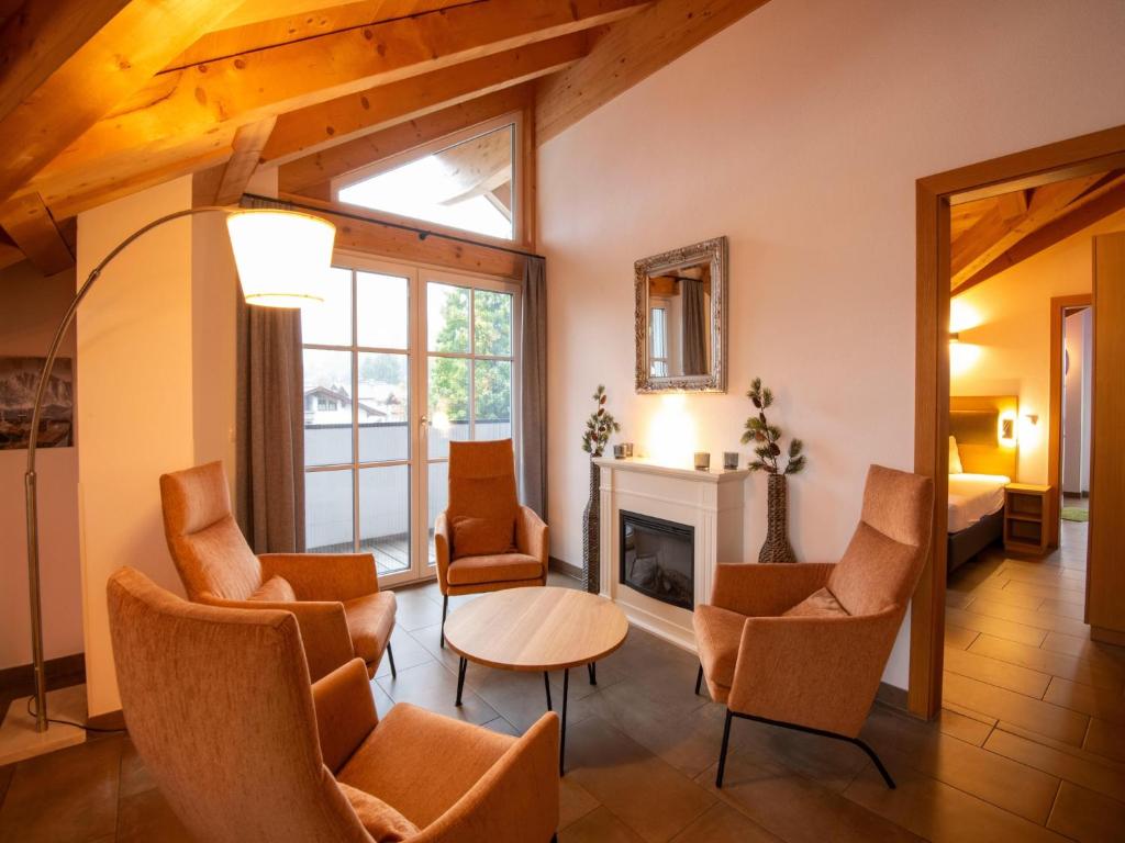 a living room with chairs and a fireplace at Luxury penthouse with Balcony, Ski Storage, Carport, Lift in Brixen im Thale