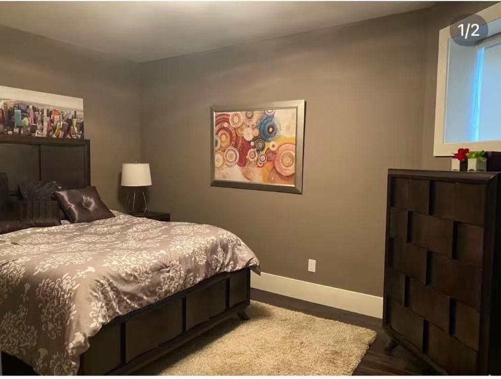 a bedroom with a bed and a painting on the wall at White Rock Joy Inn in White Rock