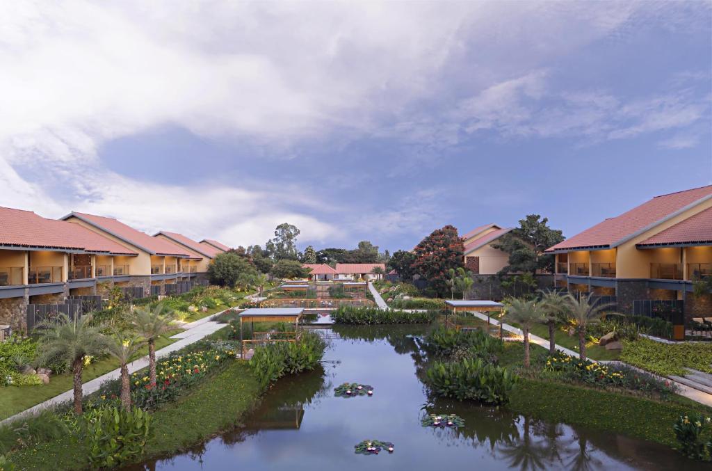 arial view of a resort with a river and buildings at Hilton Hyderabad Genome Valley Resort & Spa in Hyderabad