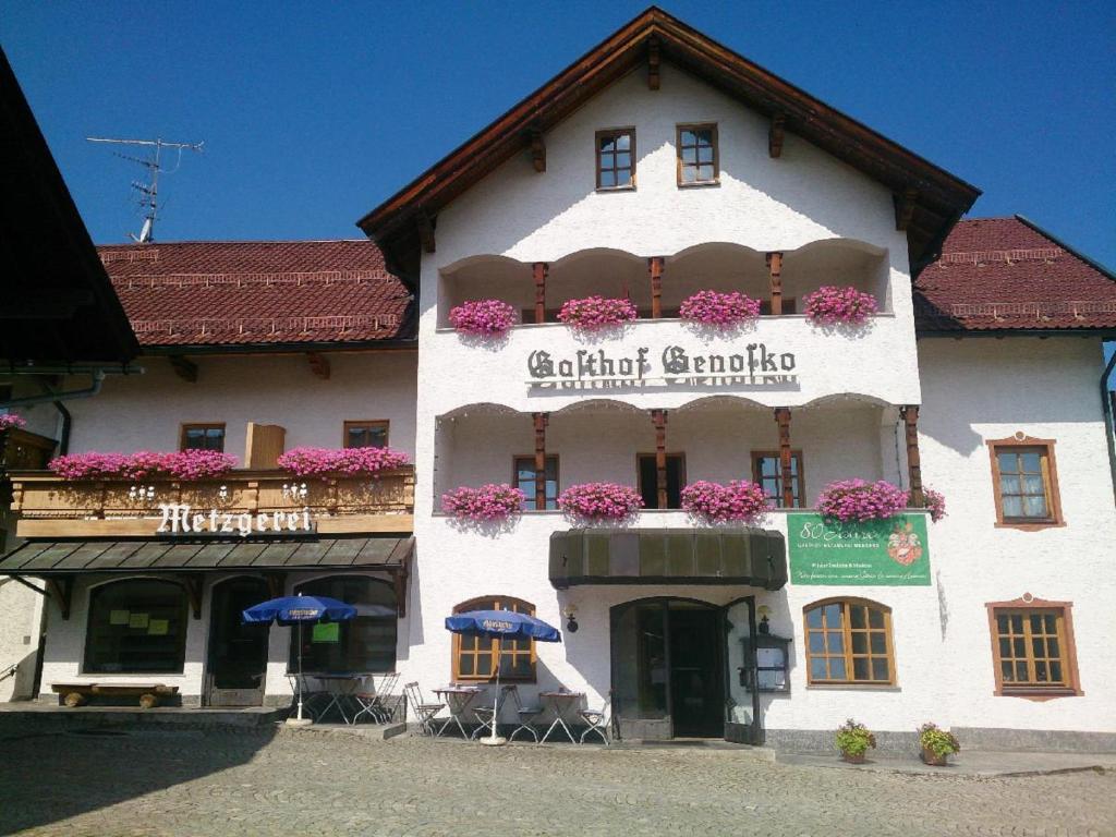 ein Gebäude mit Blumen auf der Vorderseite in der Unterkunft Gasthof Genosko in Spiegelau