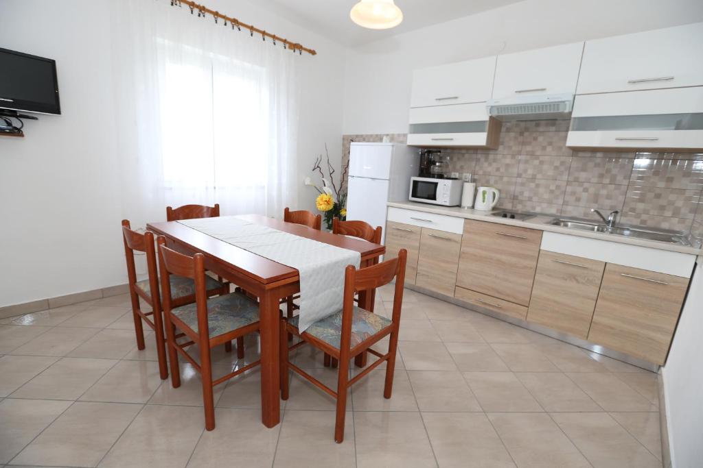 a kitchen with a dining room table and chairs at Apartment Vinka in Baška