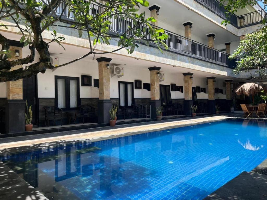 ein großer blauer Swimmingpool vor einem Gebäude in der Unterkunft Tendan Residence Hotel in Legian