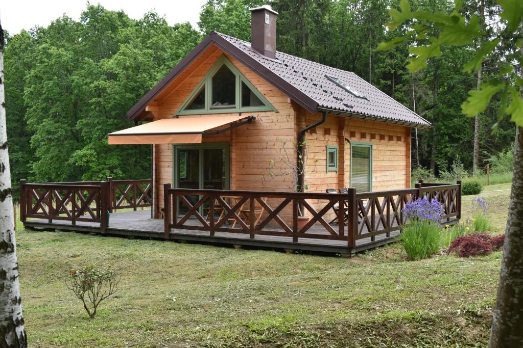 eine kleine Hütte mit einem großen Holzdeck in der Unterkunft Ogród Shinrin Yoku (Haru) Odpoczynek w Lesie in Srokowo
