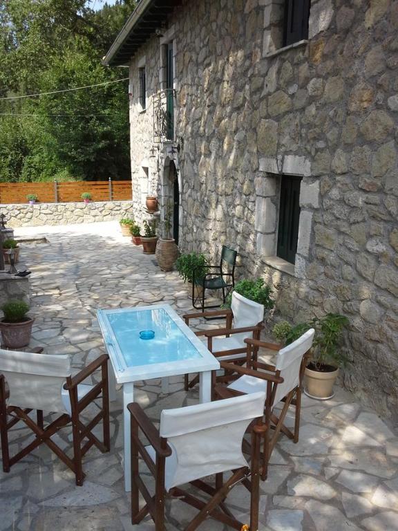 a patio with a table and chairs and a stone building at Gianna's Villa in Alexandros