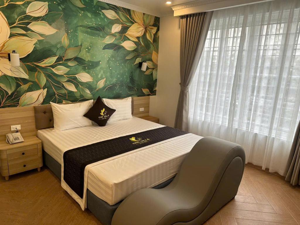 a bedroom with a large bed with a flower mural at One Villa Hotel 6 in Long Biên