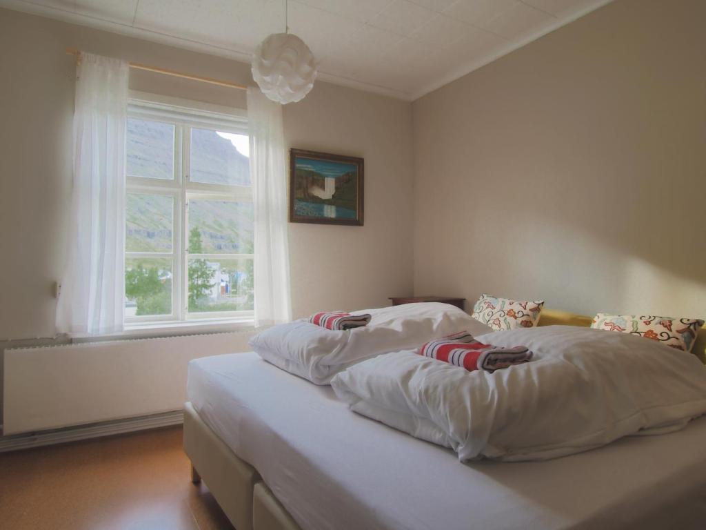 a bedroom with two beds and a window at Hafaldan HI hostel, old hospital building in Seyðisfjörður
