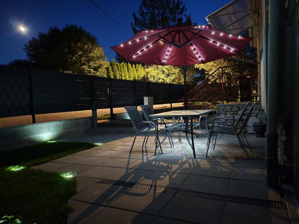 a patio with a table and chairs and an umbrella at RD ve Vilémovicích U Macochy v Moravském krasu in Jedovnice
