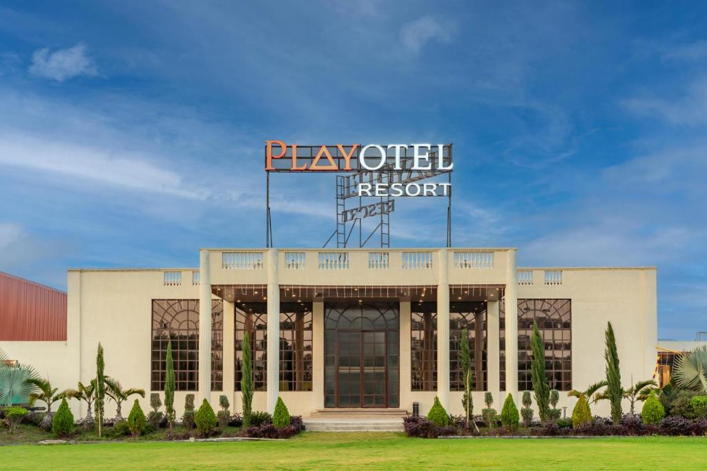 ein Gebäude mit einem großen Schild darauf in der Unterkunft Playotel Resort Indore in Indore