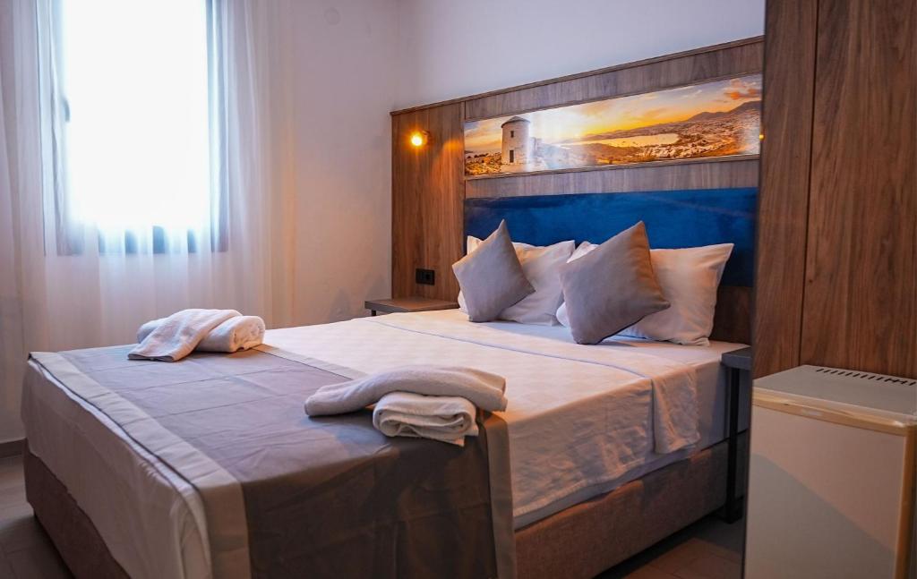 a bedroom with a large bed with two towels on it at Smart City Suites Hotel Bodrum in Bodrum City
