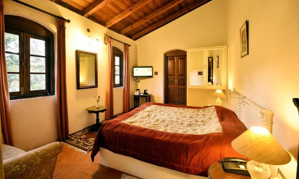 a bedroom with a bed and a table and a couch at Belvedere Palace Nainital in Nainital