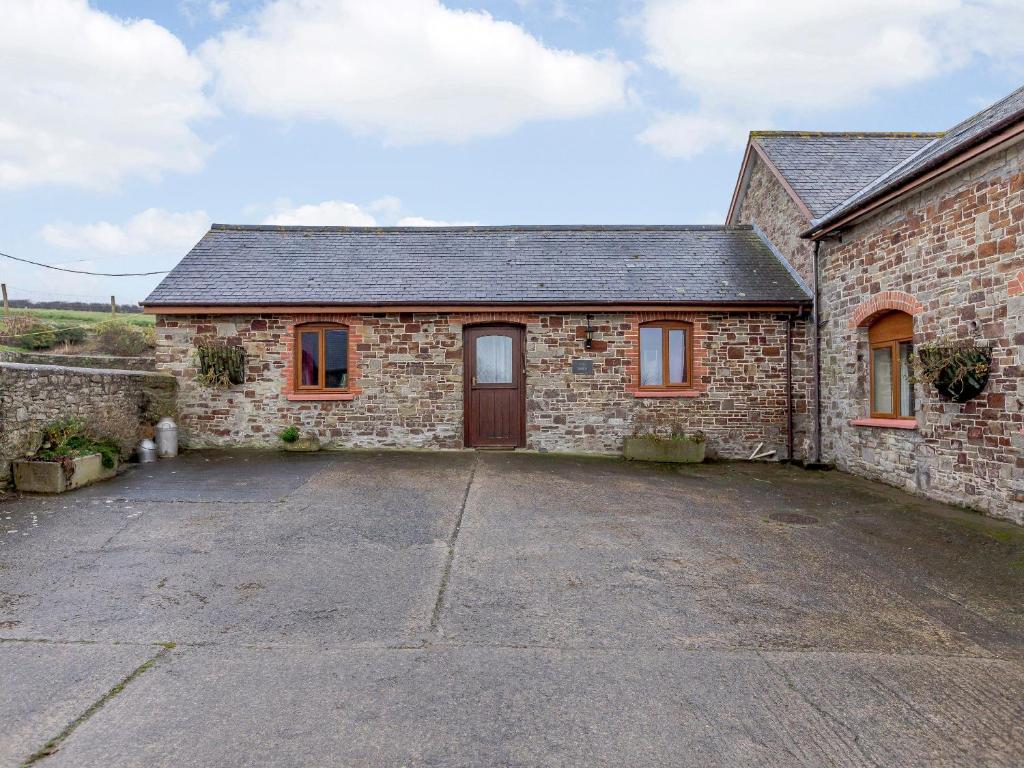 una antigua casa de piedra con un gran aparcamiento en The Barn - Uk35753, en Bideford