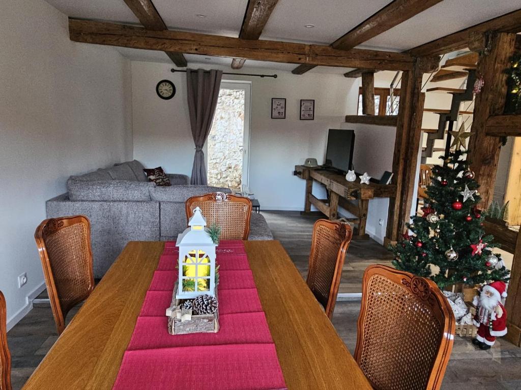 a living room with a table and a christmas tree at Gîte a la source in Bergholtz-Zell