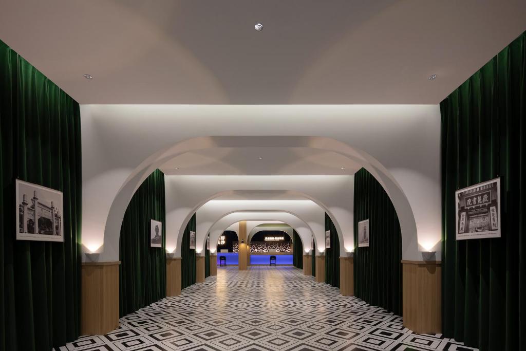a hallway in a building with green curtains at Fengqi Wutong Holiday Hotel - Changsha Wuyi Avenue Railway Station Metro Station Branch in Changsha