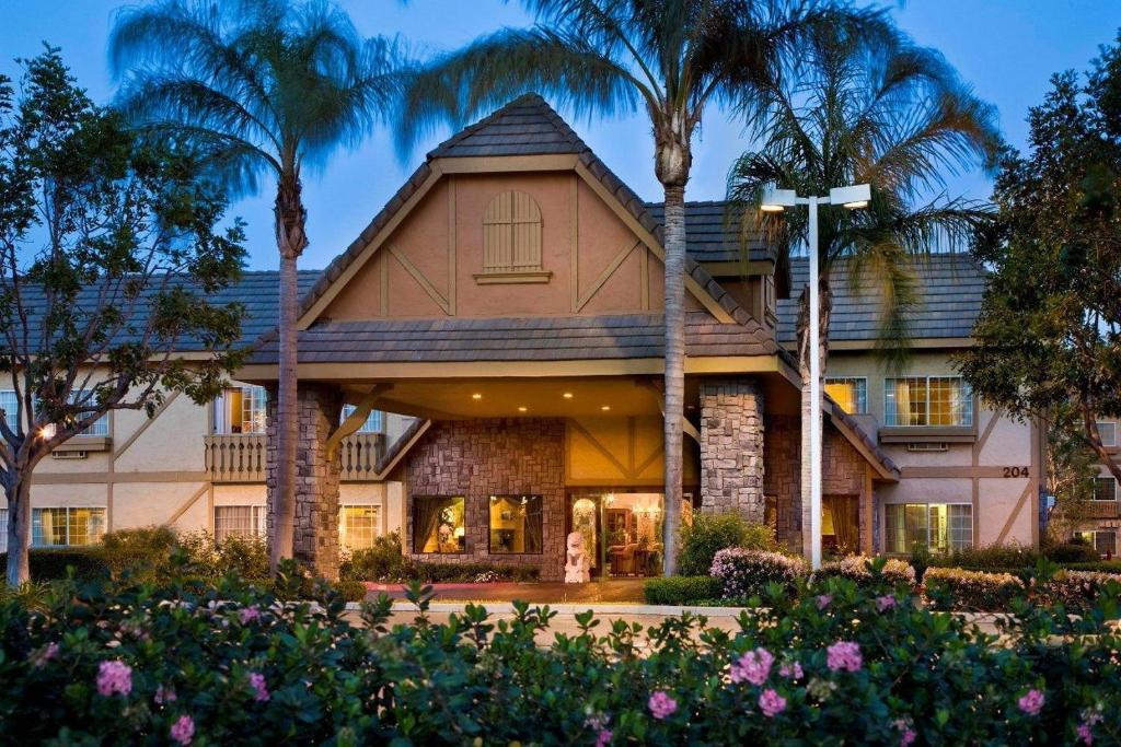 a house with palm trees in front of it at Folk Inn Ontario Airport in Ontario