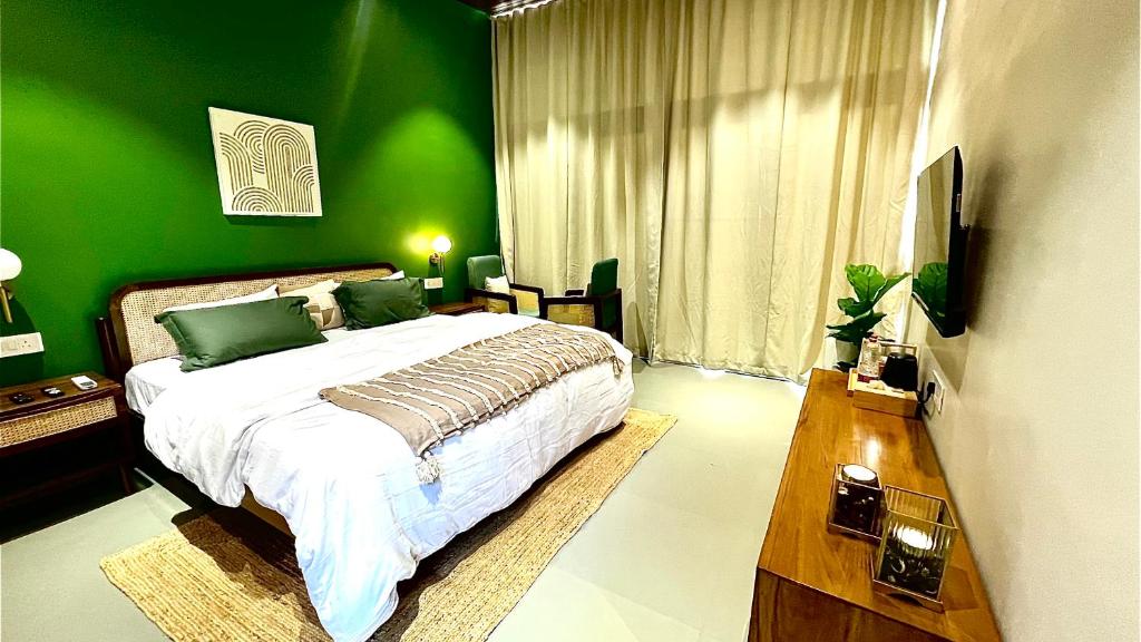 a green bedroom with a bed and a green wall at The Chalets, Mulshi in Wadgaon