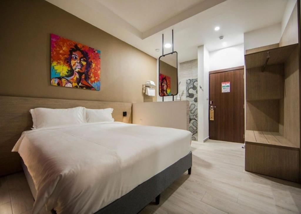 a bedroom with a large bed and a painting on the wall at Aichti Hotel in Abidjan