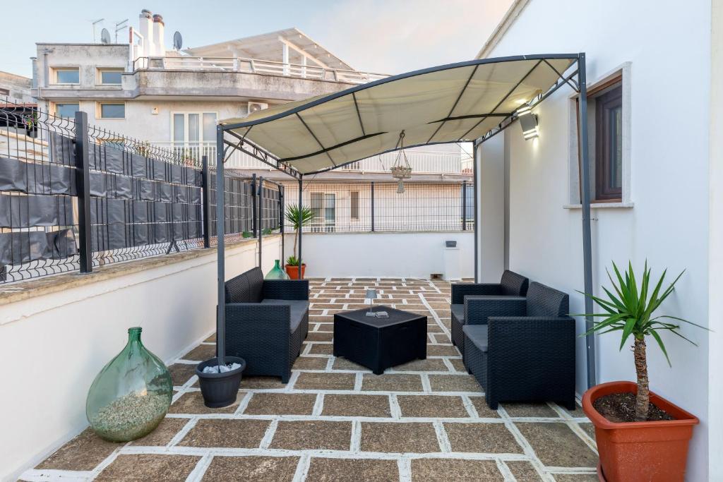 a patio with chairs and plants on a balcony at L'aurora in San Vito dei Normanni