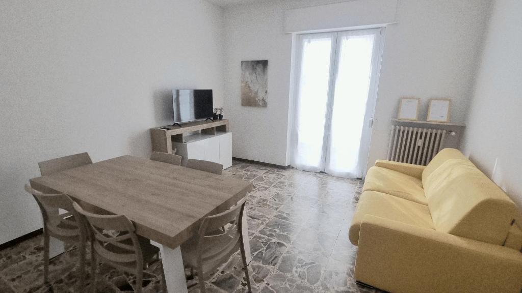 a living room with a table and a couch and a television at Sunrise in Bergamo