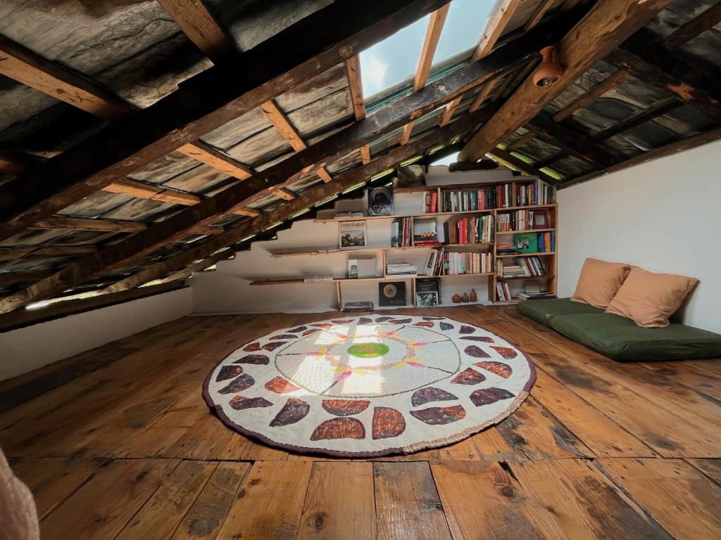 a room with a large rug on a wooden floor at The Attic Library by AVVAs Stays in Bīr