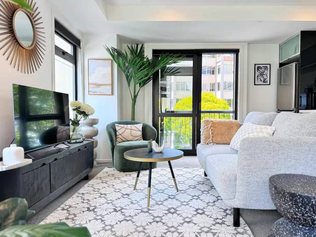 una sala de estar con un sofá y una mesa en Prime CBD Location- Walk to Spark Area & Queen St, en Auckland