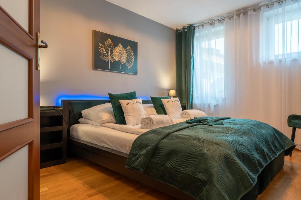 Schlafzimmer mit einem Bett mit grünen und weißen Kissen in der Unterkunft Ratuszove Love - dwie osobne sypialnie, w rynku - by Everslow in Jelenia Góra