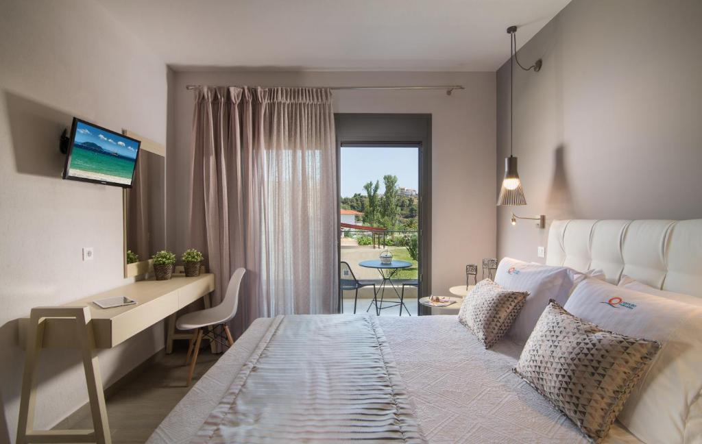 ネオス・マルマラスにあるParadise Maisonettesのベッドとデスクが備わる眺めの良い客室です。