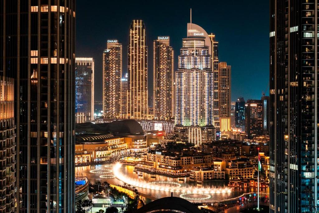 a night view of a city with tall buildings at Luxurious 3 BR with Burj Khalifa View in Downtown in Dubai