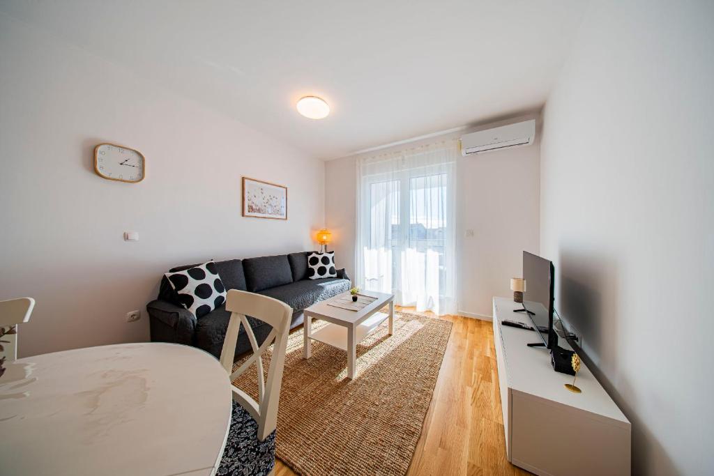 a living room with a couch and a table at Flex SelfCheckIns 191 - Zagreb - 2 Bedrooms - Parking - Loggia in Zagreb