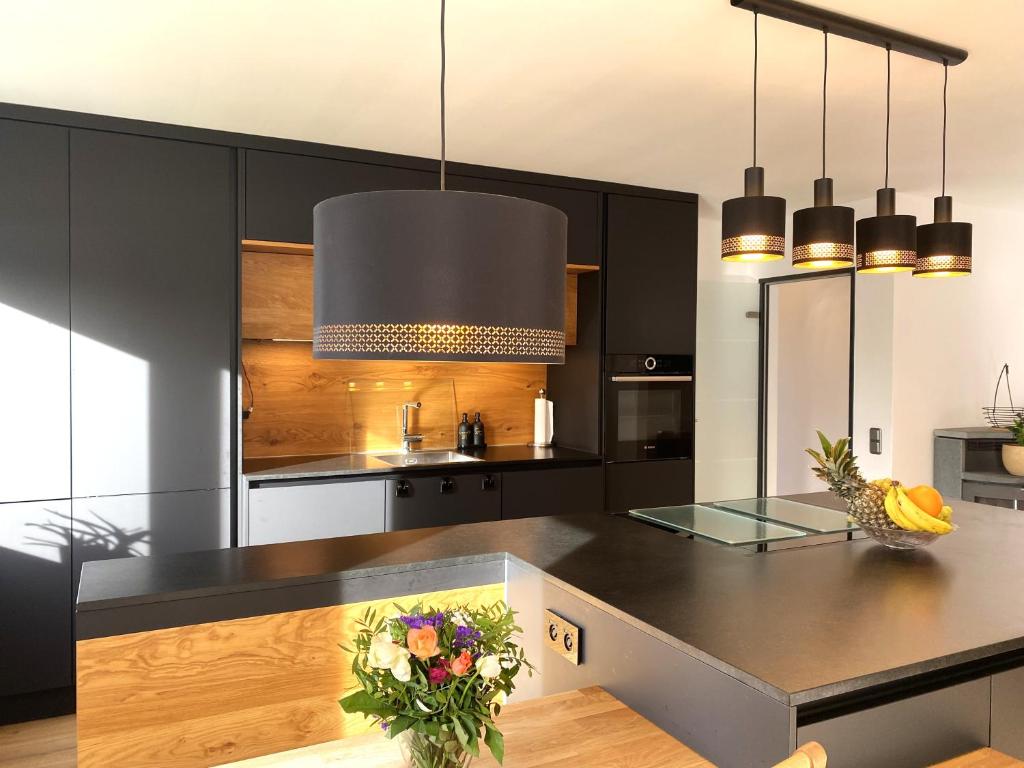 eine Küche mit schwarzen Schränken und einer schwarzen Arbeitsplatte in der Unterkunft Modernes & zentral gelegenes Ferienhaus mit Garten und Parkplatz in Memmingen