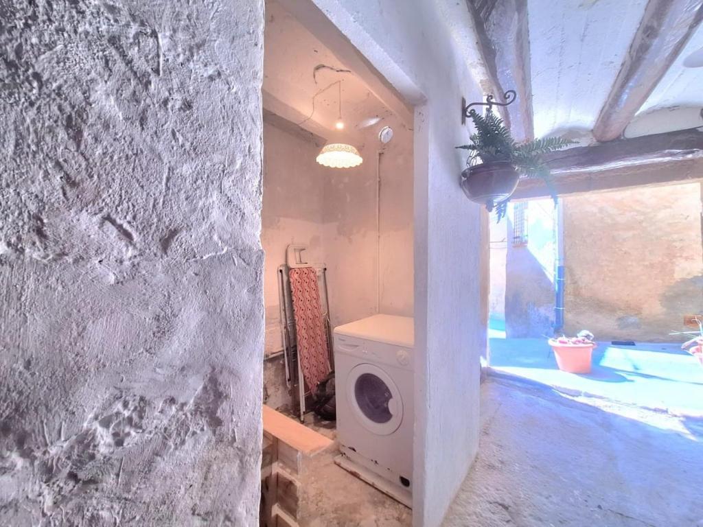 a laundry room with a washing machine in a building at Casa medieval Cal Moliner in Omells de Nagaya