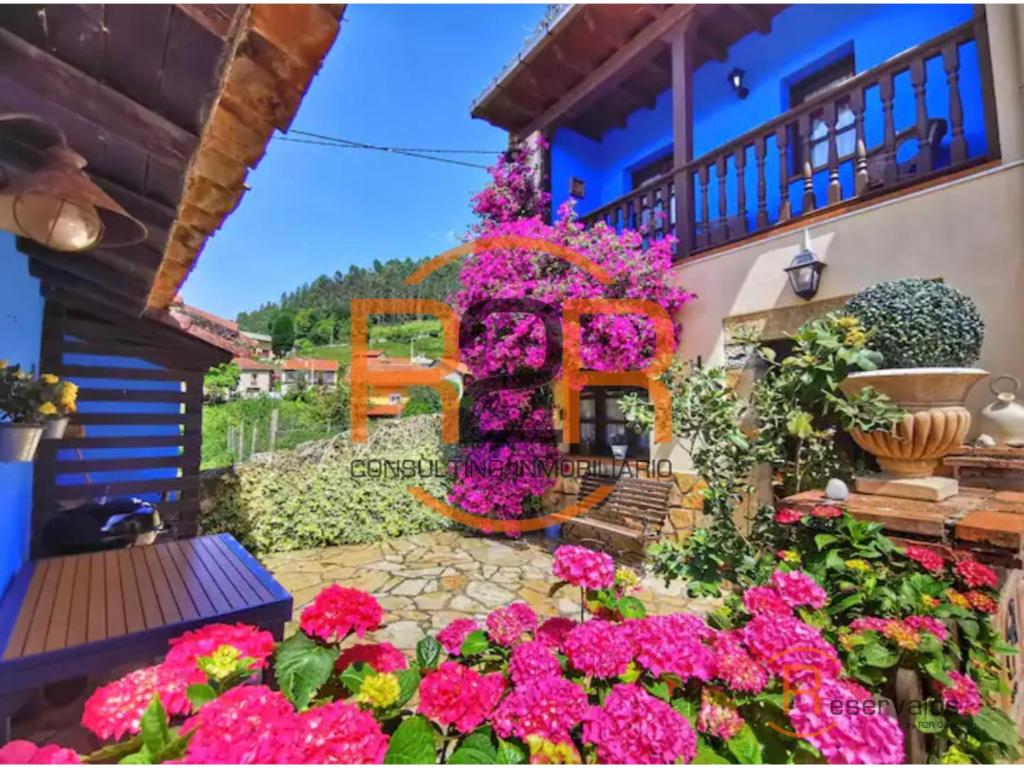 a bunch of flowers in front of a building at 15A08 El Rosal By R2R in Buelna