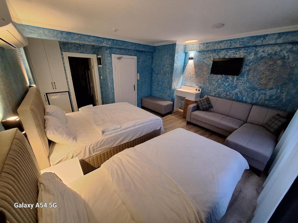 a hotel room with two beds and a couch at Dilmac Hotel in Gelibolu