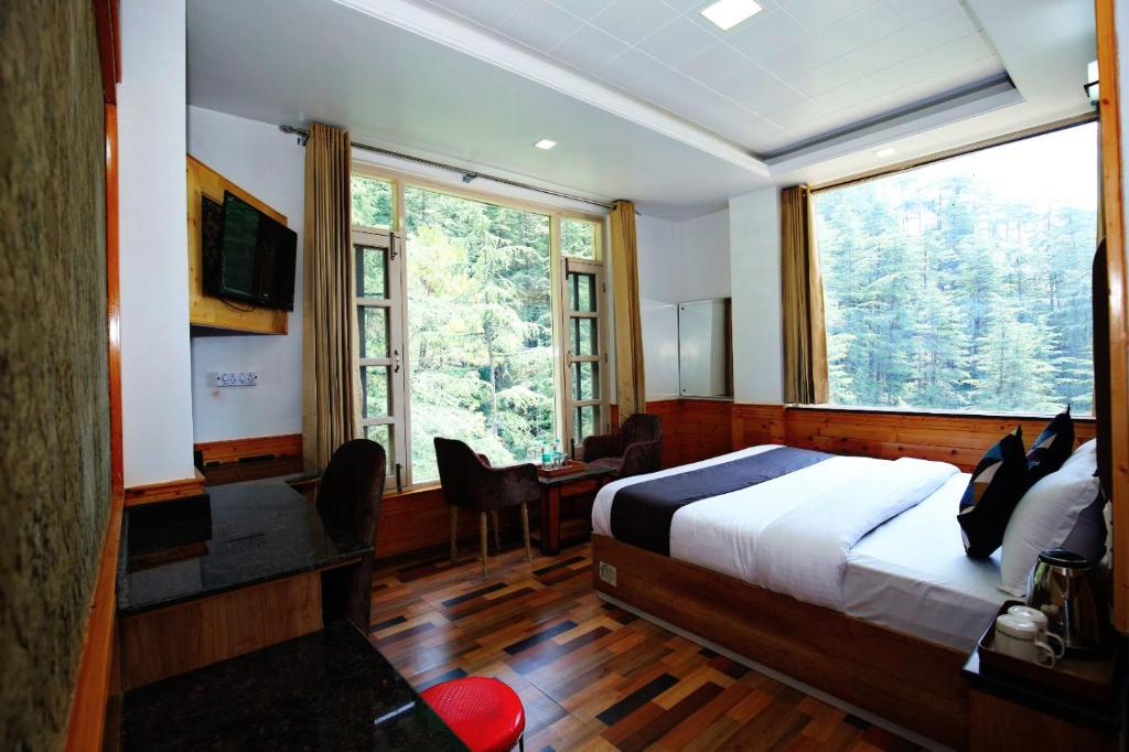 una camera da letto con un letto e una grande finestra di Verma Homestay a Shimla