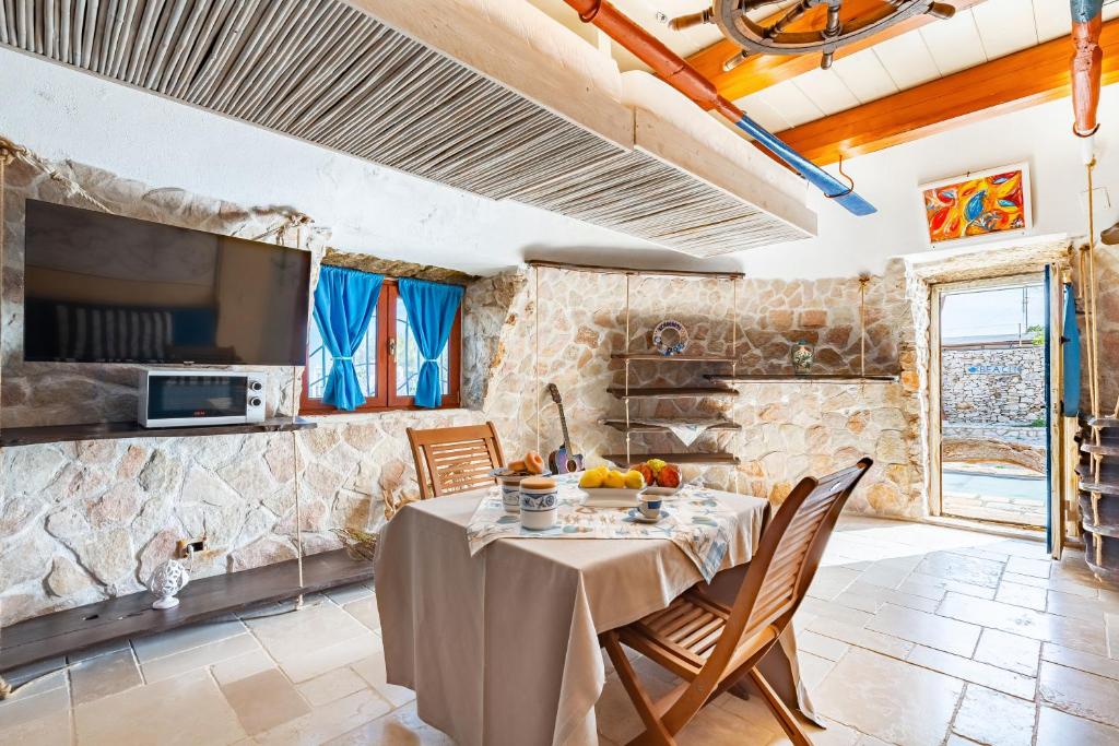 une cuisine et une salle à manger avec une table et des chaises dans l'établissement Il Trullo al Mare -Trullo by the sea- Pool & Beach, à Molfetta 73 autres photos