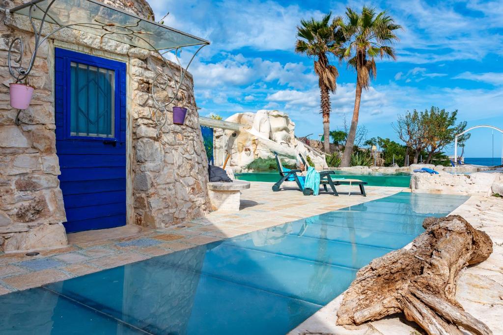 une piscine dans un complexe hôtelier avec une porte bleue dans l'établissement Il Trullo al Mare -Trullo by the sea- Pool & Beach, à Molfetta