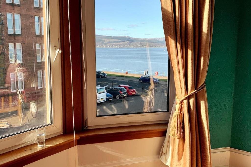 een raam met uitzicht op een parkeerplaats bij Lovely flat overlooking the Clyde in Gourock