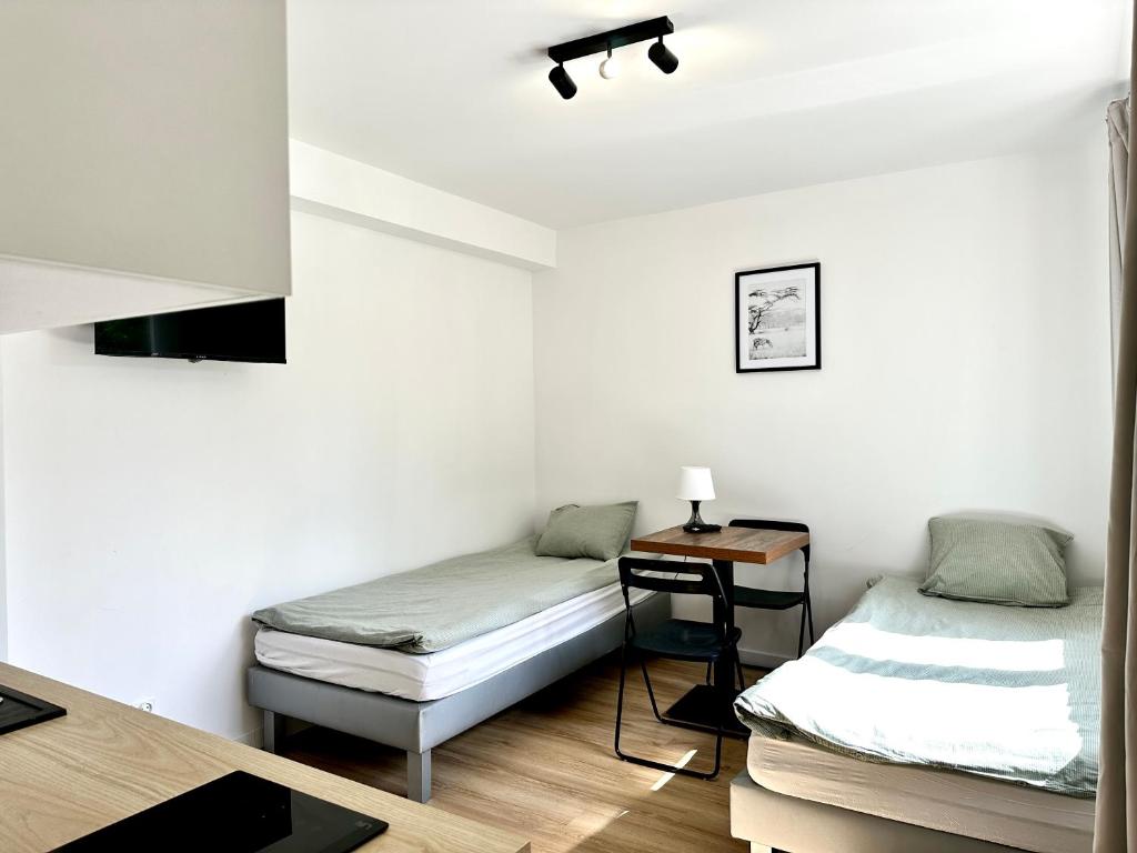 a room with two twin beds and a table at leszczynki parter III in Gdynia