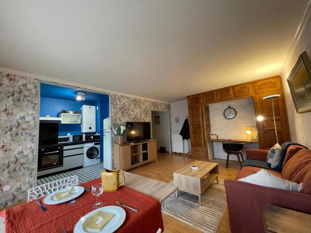 ein Wohnzimmer mit einem Tisch und ein Wohnzimmer mit einem Sofa in der Unterkunft Casino des fleurs in Vichy