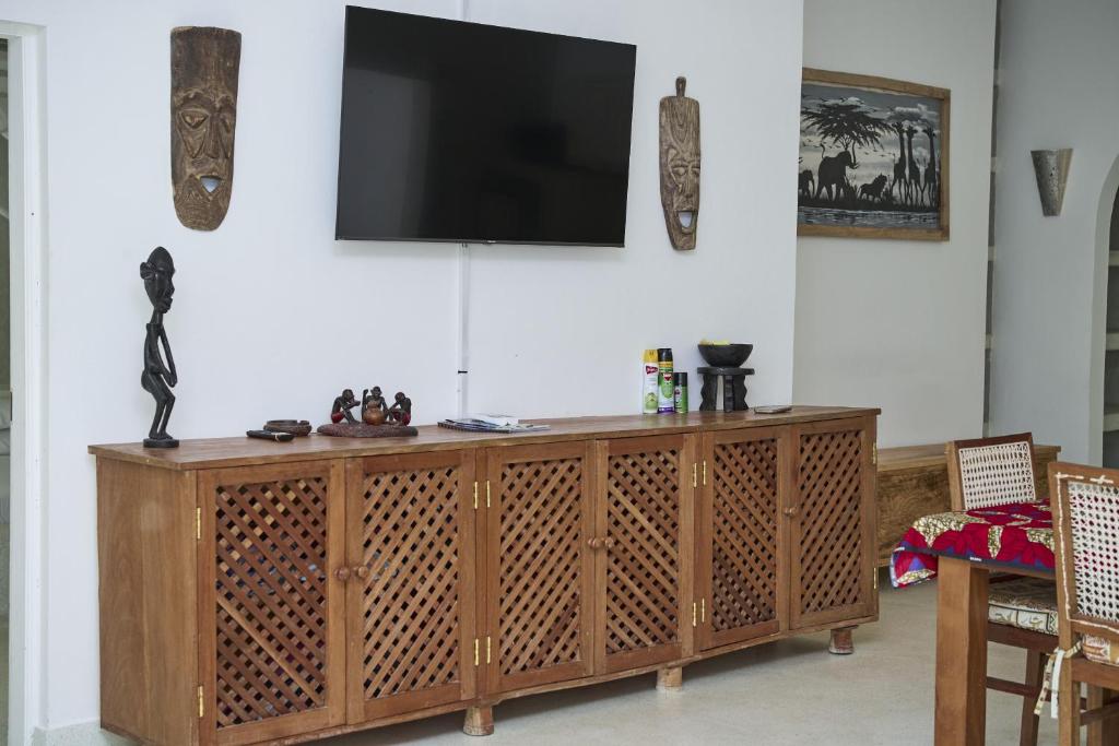 a television on top of a wooden entertainment center at White Villa Paparemo Village in Watamu