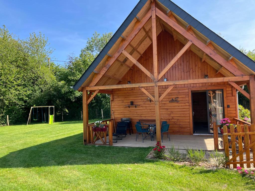 Saint-Philbert-des-ChampsにあるAu pré des chantsのパティオと遊び場を備えた木造キャビン