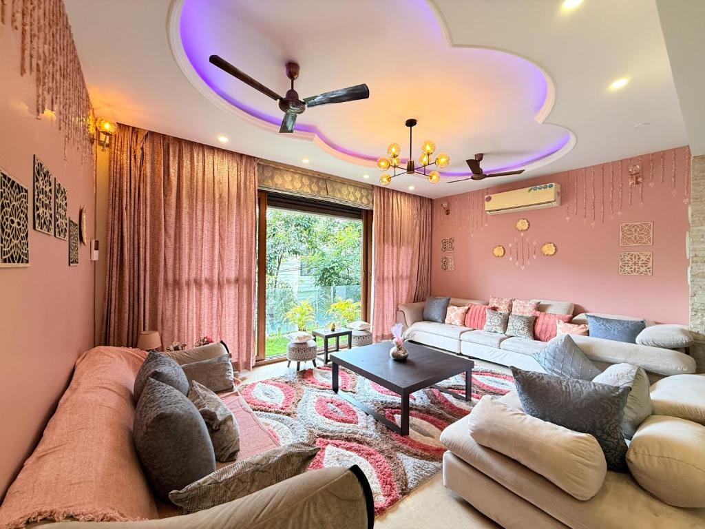 a living room with a large couch and a ceiling at Modern Mirage 4BHK Stunning Luxury Spacez Villa in Bengaluru