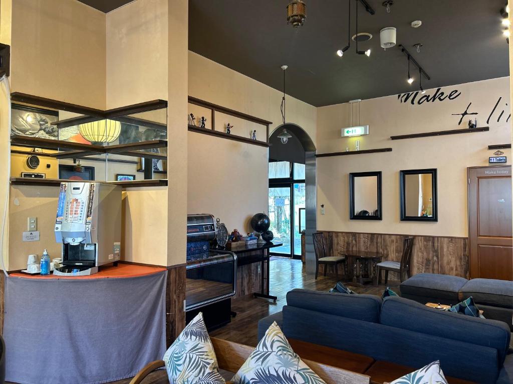 un salon avec des canapés bleus et une cuisine dans l'établissement Yufuin Tabinokura, à Yufu