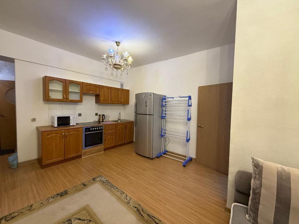 eine Küche mit Edelstahlkühlschrank und Holzschränken in der Unterkunft Enerel tsogtsolbor in Ulaanbaatar