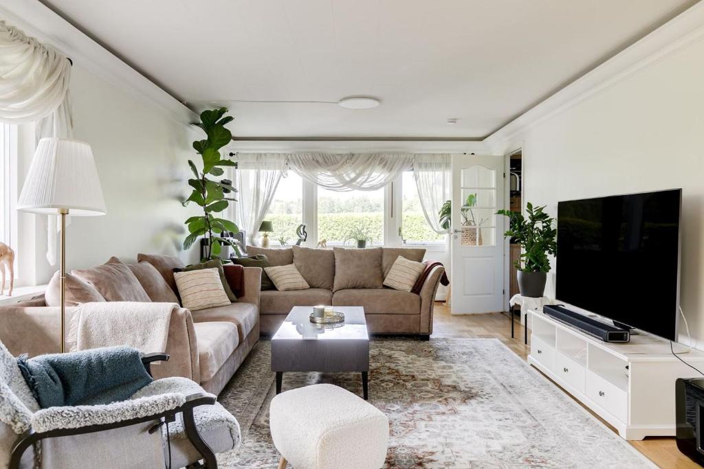 Una sala de estar con un sofá y un televisor. en Charming Swedish Villa, en Katrineholm
