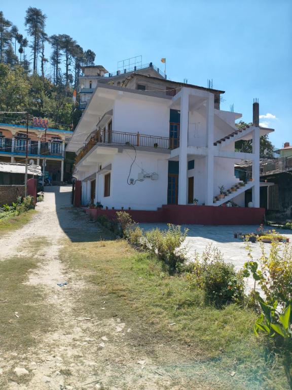 a white house on the side of a road at Nandin Guest House in Barkot