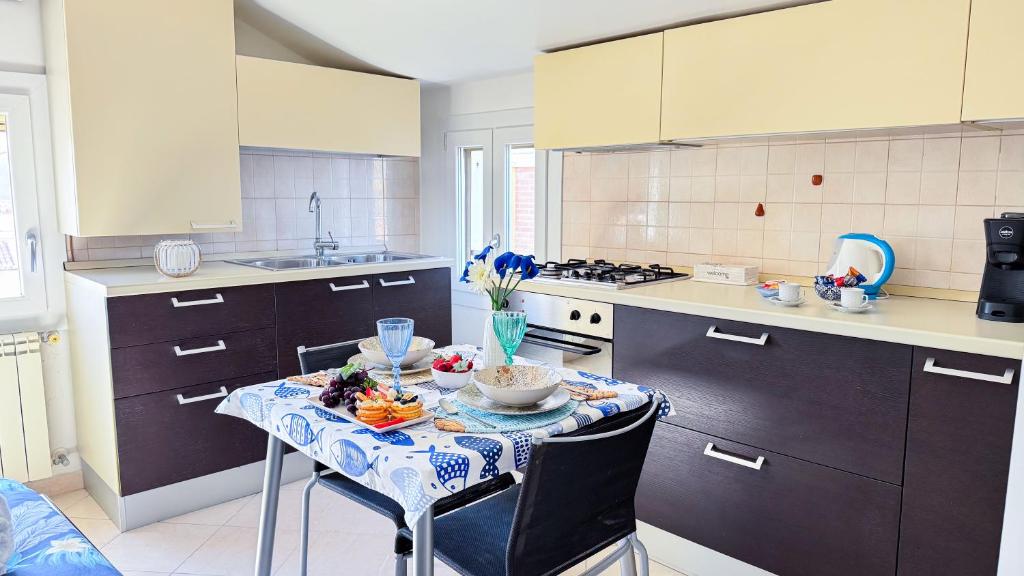 a kitchen with a table with a bowl of fruit on it at Ca’ Marea by Ca-Sa Check in Sottomarina